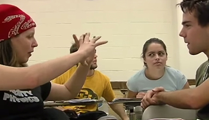 Four students talking in a classroom